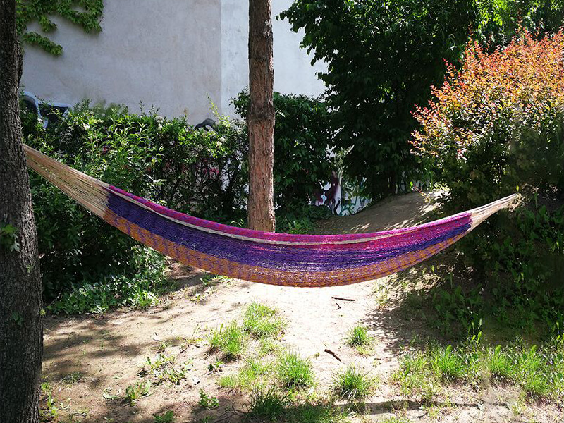 colorful hammock between two trees made by the GIN association