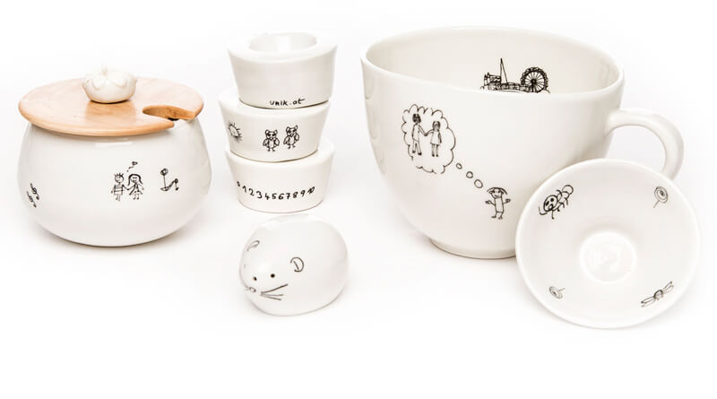 Keramikprodukte wie Schüsseln und Tassen mit lustigen schwarz-weiß Illustrationen
